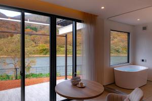 um quarto com uma banheira, uma mesa e janelas em R;MOGAMI - Vacation STAY 25489v 