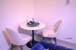 uma mesa com cadeiras cor-de-rosa e uma taça de fruta. em Luxury Penthouse em Iaundé