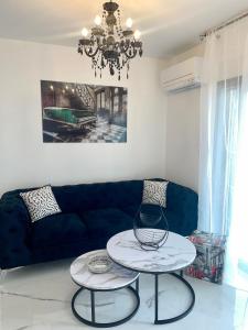 a living room with a blue couch and two tables at Apartment with free parking spot and sea view in Podstrana