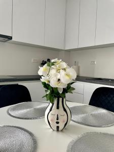 a vase filled with white flowers sitting on a table at Apartment with free parking spot and sea view in Podstrana