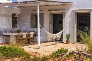 a hammock on the patio of a house at House of Harmony - Beachfront in Antiparos