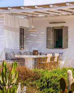 a patio with a table and chairs on a house at House of Harmony - Beachfront in Antiparos