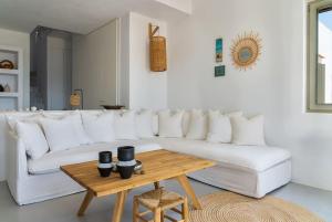 a living room with a white couch and a wooden table at House of Harmony - Beachfront in Antiparos +41 photos
