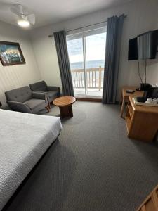 Motel Carleton Sur Mer في كارلتون سور مير: غرفة في الفندق بها سرير وأريكة ومكتب