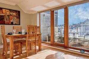 a dining room with a table and chairs and a large window at Townbridge Penthouse in Weymouth