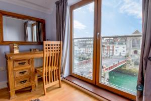 Una habitación con un escritorio y una ventana grande. en Townbridge Penthouse, en Weymouth
