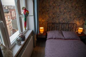 a bedroom with a bed and a window with a parrot on it at Apartament u Olechny 5 in Bydgoszcz