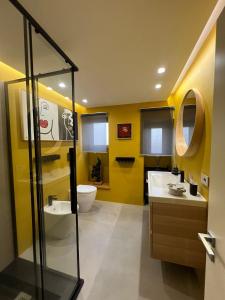 a yellow bathroom with two sinks and a toilet at ERASMO 19 Luxury Home in Catania