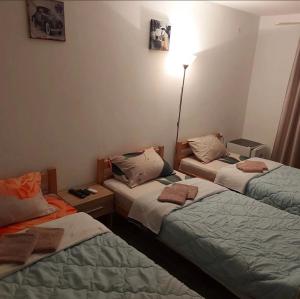 ein Zimmer mit 3 Betten und Handtüchern darauf in der Unterkunft Hostel Yugoslavija 1 in Aleksandrovac