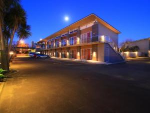 a building with a parking lot in front of it at Fitzherbert Regency Motor Lodge in Palmerston North