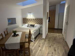 a bedroom with a bed and a table and a dining room at Apartamenty KTW Kościuszki 41 - SKY & DESIGN in Katowice