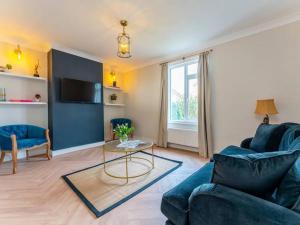 uma sala de estar com um sofá azul e uma mesa em Modern & Comfortable Urban Home em Bournemouth