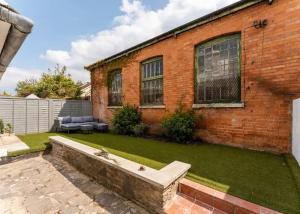 a backyard with a brick house with a lawn at Modern & Comfortable Urban Home in Bournemouth