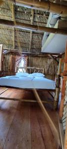 uma cama num quarto com piso em madeira em Polvo en el Aire em Santo Domingo