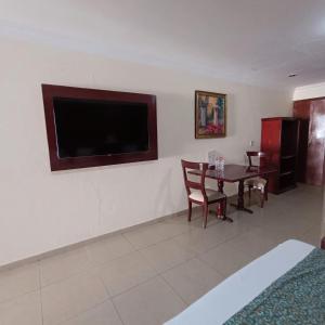 a living room with a table and a flat screen tv at Hotel Confort Plaza in Culiacán
