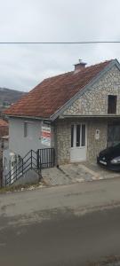 ein Steinhaus mit einem davor geparkt in der Unterkunft Hostel Yugoslavija 1 in Aleksandrovac