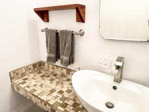 a bathroom with a white sink and a mirror at Fenix Hotel - On the Beach in Sámara