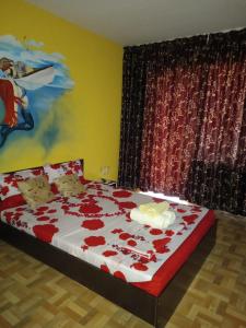 EL Capitano - Mamaia Nord في مامايا نورد نافورداي: غرفة نوم عليها سرير وورد احمر