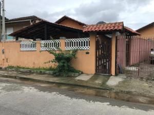 uma casa com uma varanda branca numa rua em Villaggio Miravela em Caraguatatuba