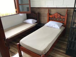 2 camas individuales en una habitación con ventana en Villaggio Miravela, en Caraguatatuba
