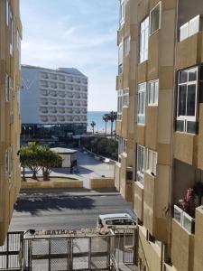 a view of the ocean from the balcony of a building at Apartamento Playa Victoria I in Cádiz