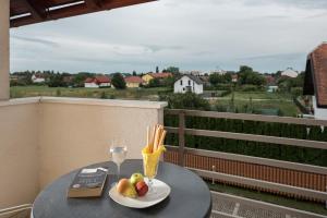 a table with a plate of food and a glass of wine at Apartments Moravske Toplice in Moravske-Toplice