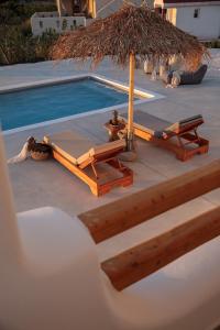 una piscina con due sedie a sdraio e un ombrellone di Nymphée Luxury Villas ad Agia Anna Naxos