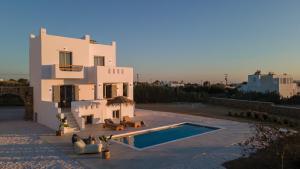 a house with a swimming pool in front of it at Nymphée Luxury Villas in Agia Anna Naxos