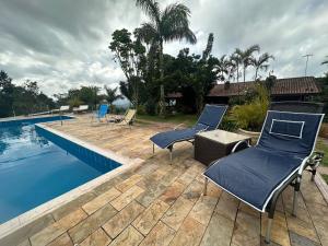 um pátio com 2 cadeiras e uma piscina em Rancho NPI em Guarulhos