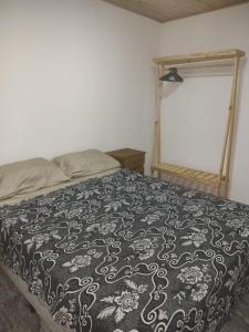 1 dormitorio con 1 cama con manta blanca y negra en Meraki en Guaymallén