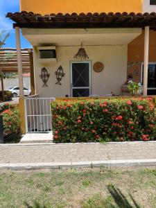 a house with a gate and a bush of flowers at Na Praia - Cicb - Setor de Clubes Sul in Barra de São Miguel