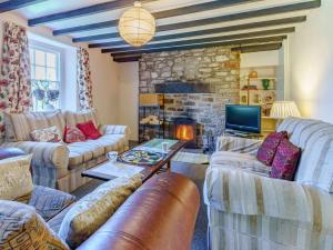 a living room with couches and a stone fireplace at 4 Bed in Llangynidr BN305 in Llangynidr