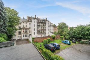 deux voitures garées dans une cour devant un bâtiment dans l'établissement Modernes 3 Zimmer Apartment mit Balkon, à Wuppertal