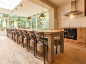 a kitchen with a long wooden table and chairs at Cozy home with lots of privacy, in the forest in De Bult
