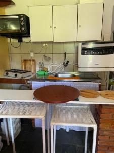 a kitchen with a table and two chairs and a microwave at Na Praia - Cicb - Setor de Clubes Sul in Barra de São Miguel