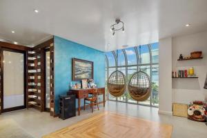 ロサンゼルスにあるMarina Del Rey Peninsula 3 Bedroom Exceptional Penthouseの青い壁の客室で、デスクと椅子が備わります。