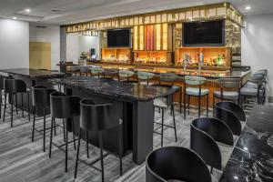 eine Bar mit schwarzen Barhockern in einem Zimmer in der Unterkunft DoubleTree by Hilton Sarasota Bradenton Airport in Sarasota
