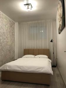een slaapkamer met een groot wit bed met een raam bij MODERN & ELEGANT Apartament in Craiova +12 foto's