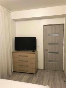 a bedroom with a television on a dresser next to a door at MODERN & ELEGANT Apartament in Craiova +12 photos