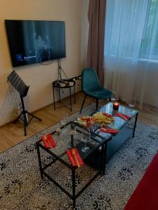 een woonkamer met een tafel met eten erop bij Cosy apartment near downtown and airport in Vilnius