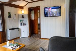 a living room with a television on a wall at Ferienwohnung zum Eiling in Bestwig