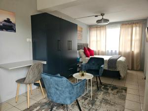 a bedroom with a bed and a table and chairs at Deluxe Guest Suite at Warner Beach in Kingsburgh