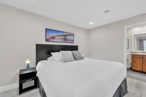 a white bedroom with a large bed and a bathroom at Trinity Suite 2b 2b Strip View in Las Vegas