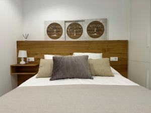 a bedroom with a large bed with a wooden headboard at Apartamento Lux Santiago in Santiago de Compostela