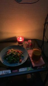 a plate of food on a table with a candle at Cosy apartment near downtown and airport in Vilnius