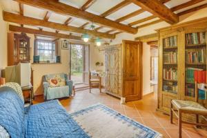 een woonkamer met een blauwe bank en boekenplanken bij LA CASINA DI LONNANO in Pratovecchio