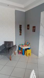 a living room with a table and a chair at Apart 3qtrs á 1200m da praia de Itapuã in Vila Velha