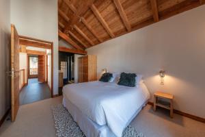 um quarto com uma cama branca e um tecto de madeira em Chalet Snowbird 5 étoiles, Serre-Chevalier em La Salle Les Alpes