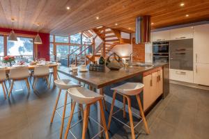 a kitchen with a large island with bar stools at Chalet Snowbird 5 étoiles, Serre-Chevalier in La Salle-les-Alpes