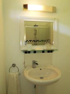 W łazience znajduje się umywalka i lustro. w obiekcie VJ's Guesthouse Mountain View w mieście Café